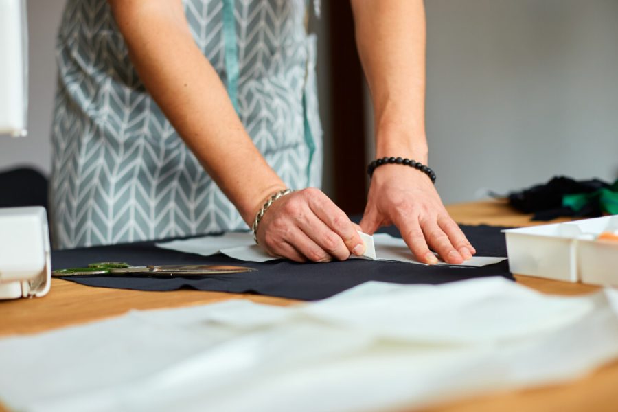 Man dressmaker making sewing patterns, male tailor working with sewing pattern in atelier, textile industry, hobby, small business workspace. Creation process DIY, Workplace of seamstress.